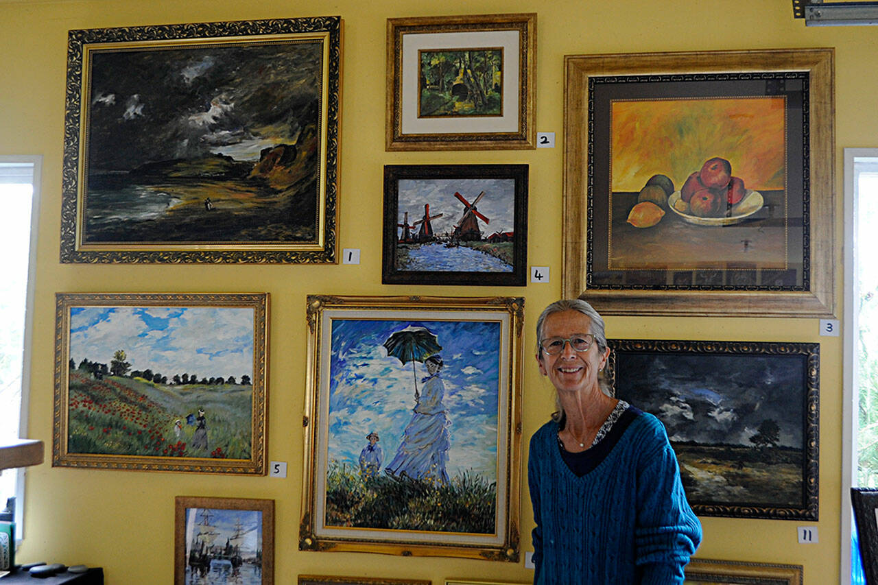Carrie Rodlend plans to auction off more than 30 reimagined classic paintings, such as Claude Monet’s “Woman with a Parasol – Madame Monet and Her Son” on Saturday, Sept. 11 from her home studio at 562 Holgerson Road in Dungeness. She’s worked more than a year beside her students on reimagining classic paintings to teach new techniques. Sequim Gazette photo by Matthew Nash