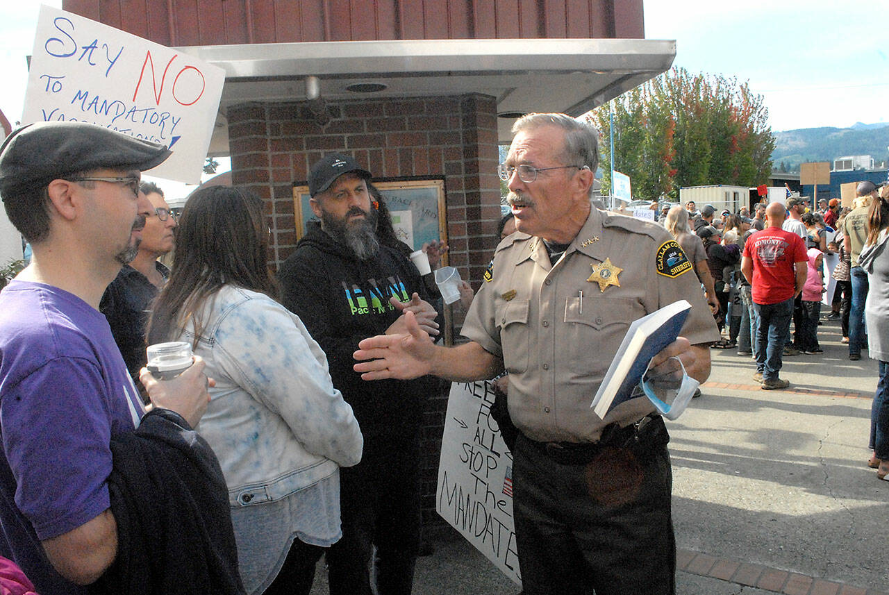 Clallam County Sheriff Bill Benedict, center, talks with vaccination mandate protesters at the main entrance of the courthouse on Sept. 3. Photo by Keith Thorpe/Olympic Peninsula News Group