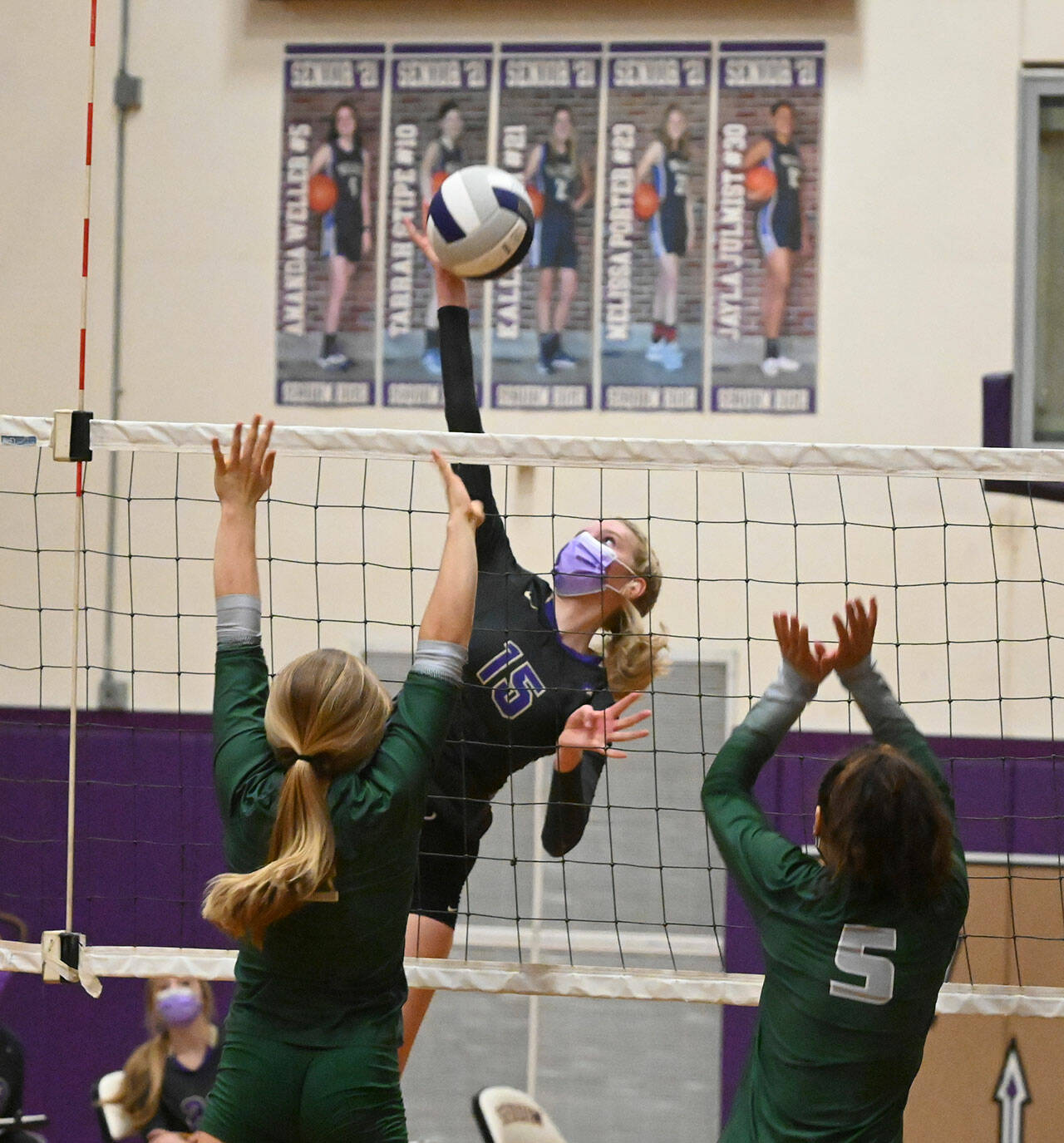 Above: Sequim’s Kendall Hastings, center, looks to hit past the block of Lillian Halberg, left, and Karma Williams in the Wolves’3-1 win over their rivals Sept. 9. Right: Sequim’s Kelsi Bergeson, right, looks to hit past Port Angeles’ Ava Hairell in the second Sequim Gazette 
photos by Michael Dashiell