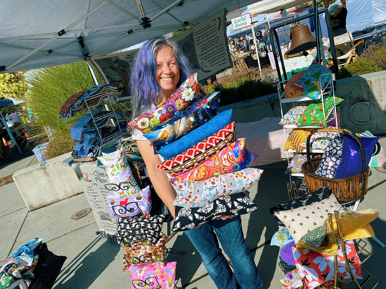 KarenLynn Robinson displays some of the BlissPillows she offers at her booth at the Sequim Farmers & Artisans Market Saturday. Photo by Emma Jane “EJ” Garcia