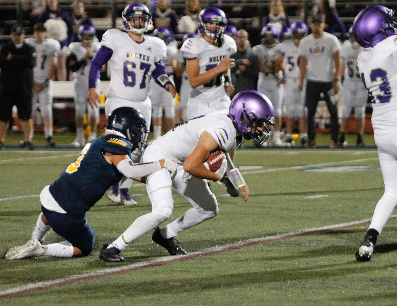 Sequim’s Aiden Gockerell makes a reception and tries to escape the grasp of Bainbridge defensive back Jeff Utter in the Wolves’ 48-10 loss at Bainbridge on Sept. 24. Photos by Mark Krulish/Kitsap News Group