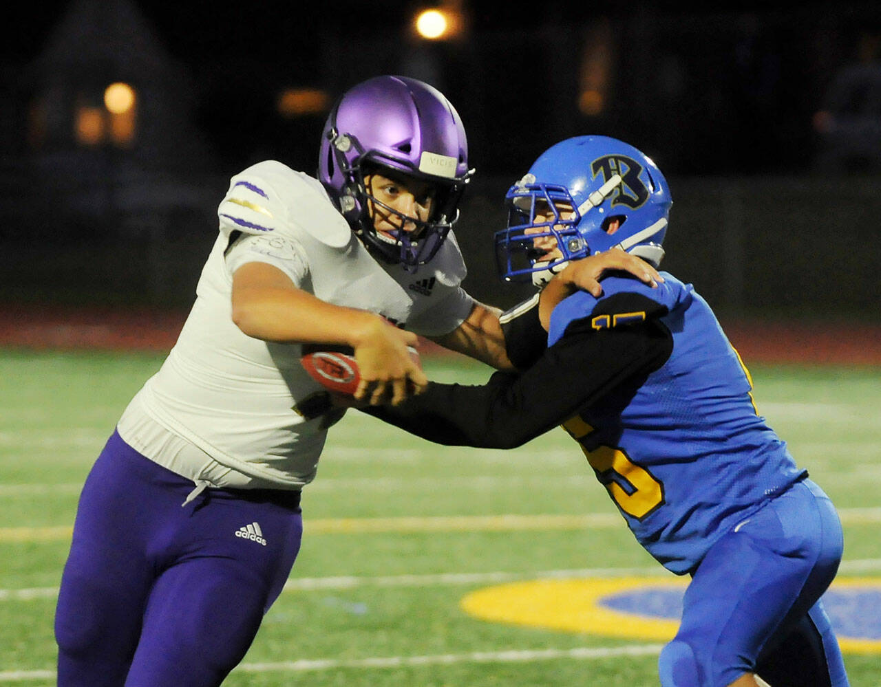 Sequim quarterback Lars Wiker, left, tries to avoid the grasp of a Bremerton defender in the Wolves’ 35-29 loss at Bremerton on Sept. 30. Sequim Gazette photo by Michael Dashiell