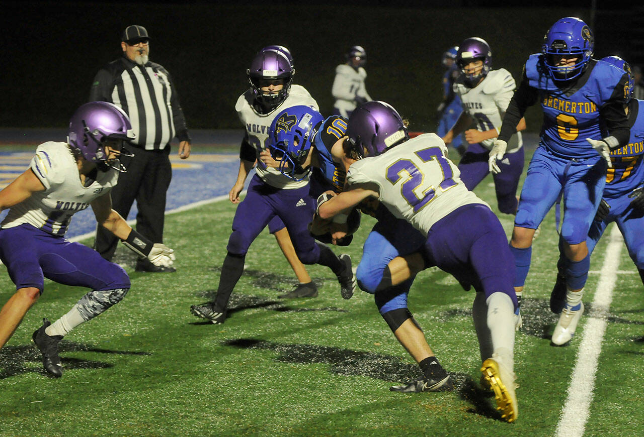 Sequim’s Mason King (27) and Aiden Gockerell (11) try to stop Jakobi Serrato in a Sept. 30 Olympic League match-up. Sequim Gazette photo by Michael Dashiell