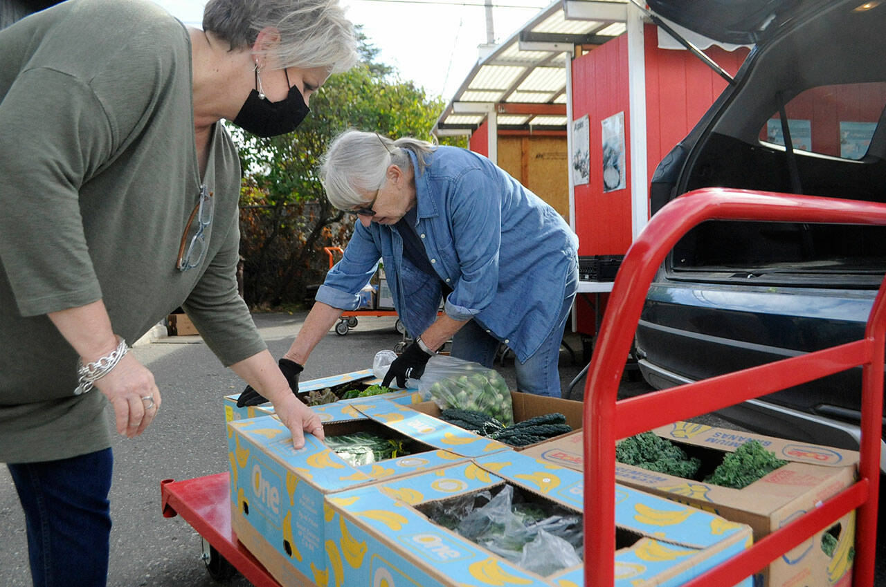 Andra Smith, executive director of the Sequim Food Bank, left, and volunteer Isabelle Dunlop prep some donations from River Run Farm last week. The facility is readying to begin accepting community donations again after 18 months due to Covid-19 precautions and storage issues. Organizers specifically seek low sodium soups, low sugar cereal, macaroni and cheese, and condiments. Sequim Gazette photo by Matthew Nash