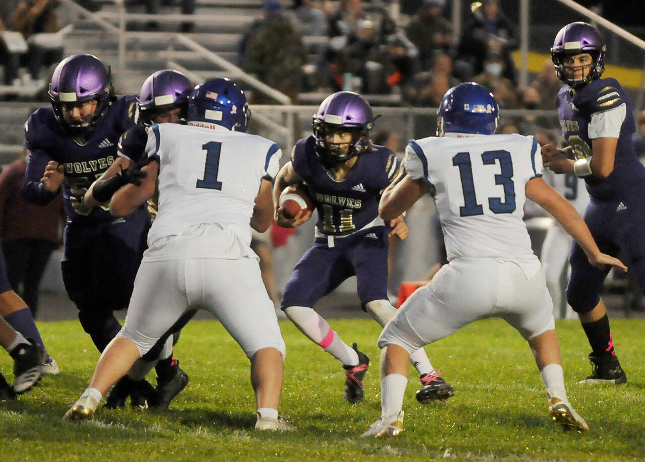 Sequim’s Aiden Gockerell, center, looks for running room in the Wolves’ 29-28 win over North Mason on Oct. 16. Sequim Gazette photo by Michael Dashiell