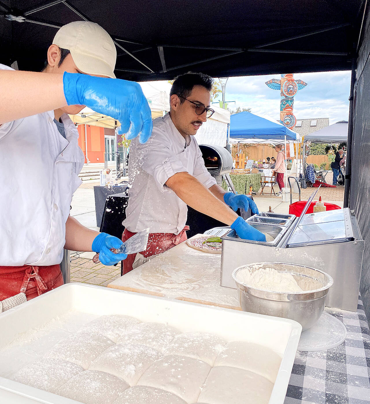 Staff at Ulivo Pizzeria prep fresh pizza at the Sequim Farmers & Artisans Market. Photo by Emma Jane Garcia