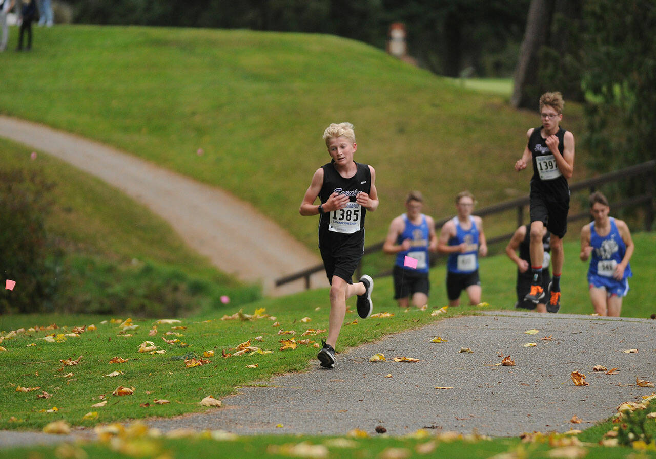 Sequim’s Connor Goff, left, and Sean Southard race at the Olympic League championships at The Cedars at Dungeness golf course on Oct. 21.