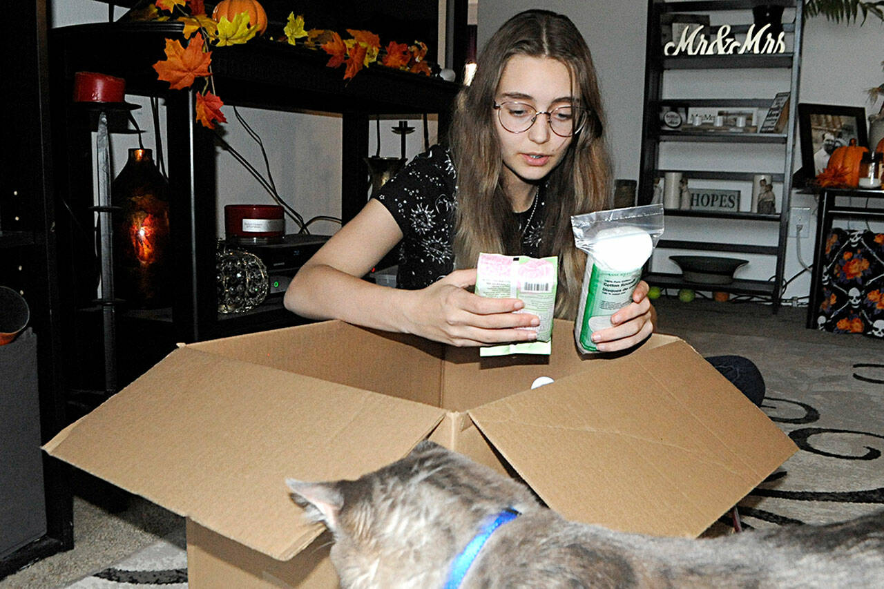 River Jensen, 15, sorts one of the many boxes of toiletries she plans to distribute to local agencies prior to Christmas. Sequim Gazette photo by Matthew Nash