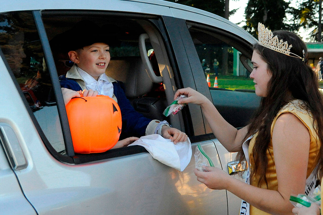 Princess Allie Gale of the Sequim Irrigation Festival hands candy to Brody Nisbet, 10, during the Sequim Prairie Grange’s drive-through event on Oct. 30. See more photos, A-8. Sequim Gazette photo by Matthew Nash
