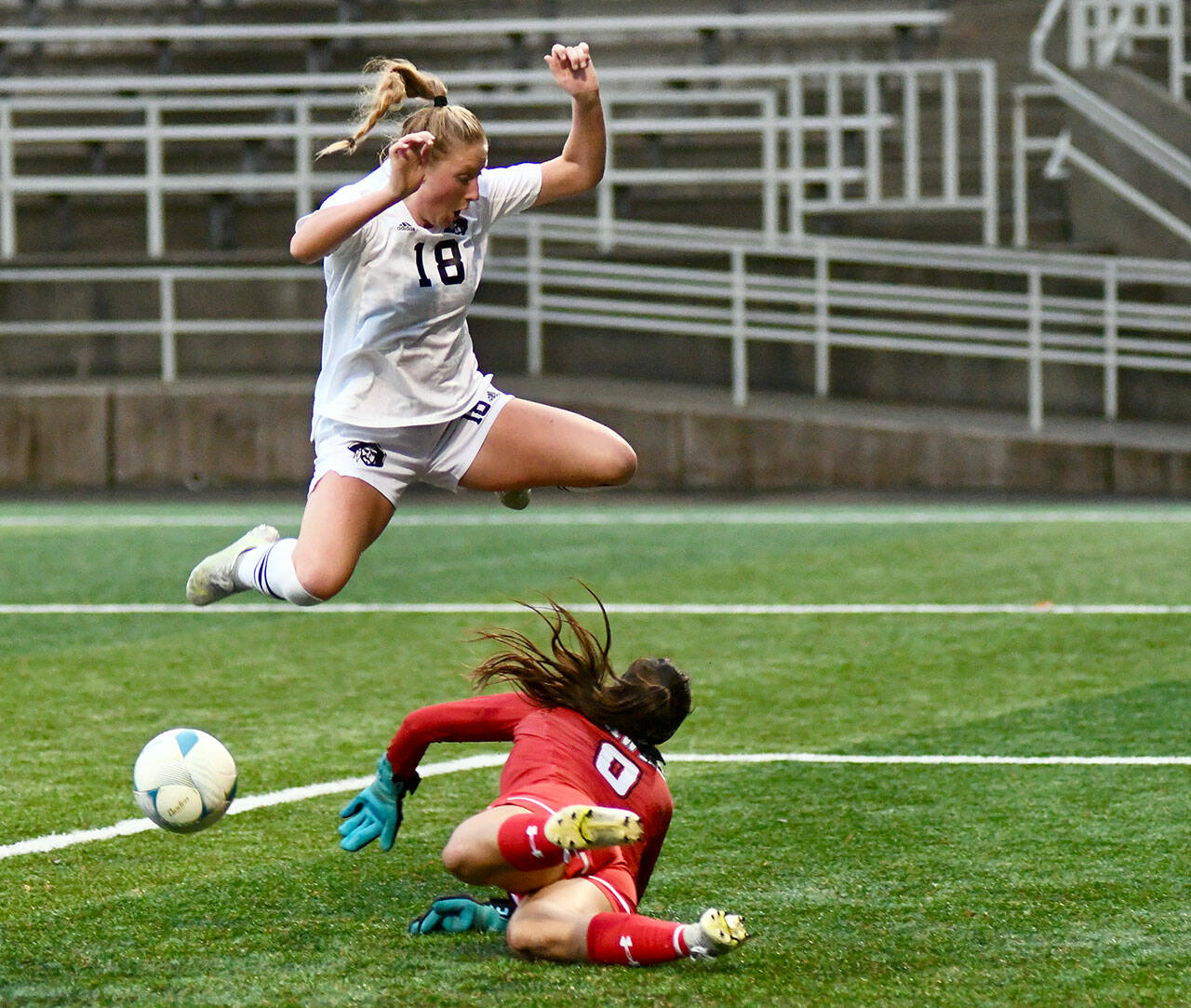 Peninsula College’s Kyrsten McGuffey hurdles Columbia Basin goalkeeper RiaJo Schwartz during the first half of the Pirates 2-1 come-from-behind win over the Hawks in the NWAC Semifinals on Nov. 12 at Starfire Sports Stadium. Photo by Jay Cline/Peninsula College