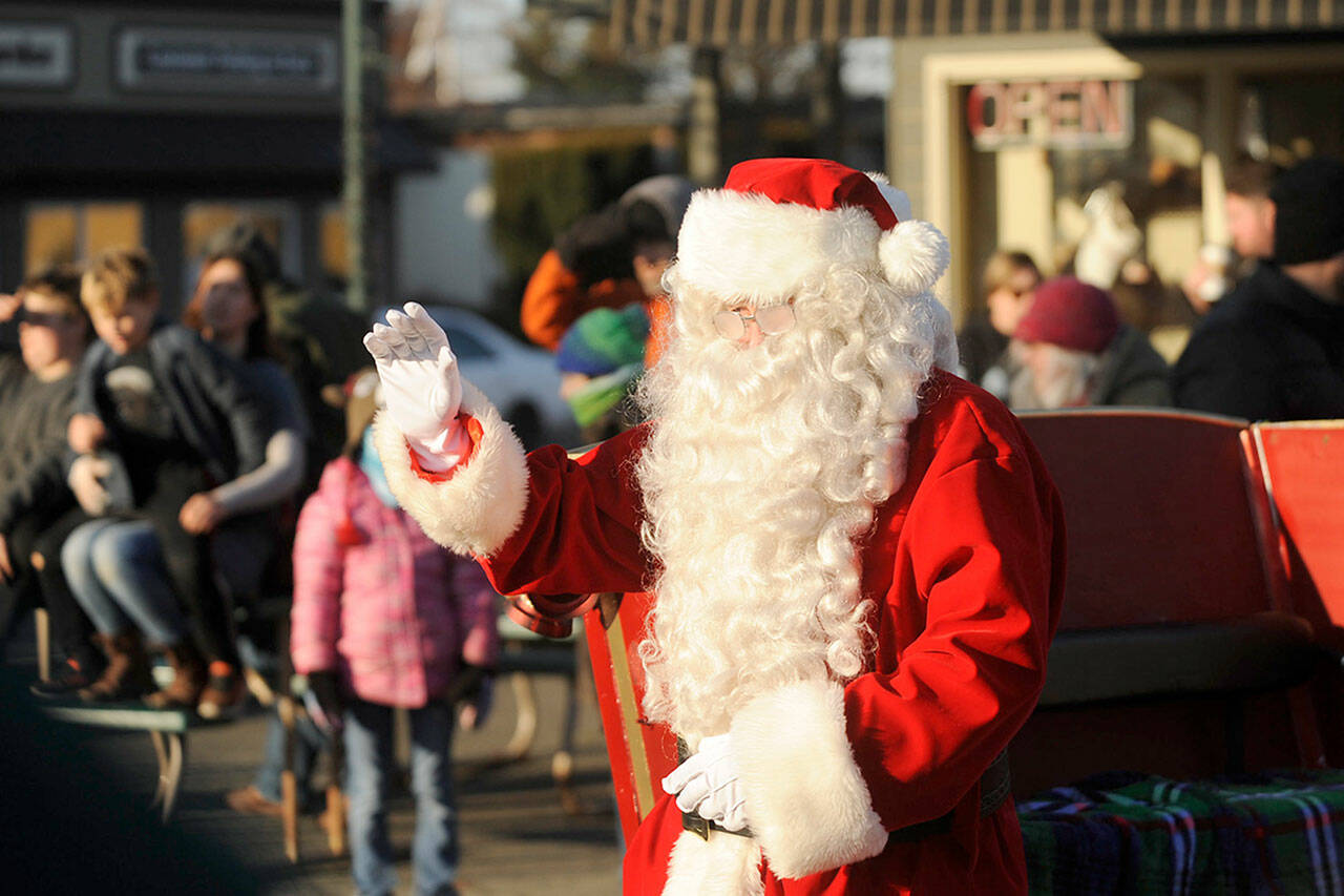 Santa Claus waves to a crowd at the 2019 Home Town Holidays event. He returns with Sequim Irrigation Festival royalty 2-4 p.m. Saturday, Nov. 27 for photo-ops and songs. Sequim Gazette file photos by Michael Dashiell