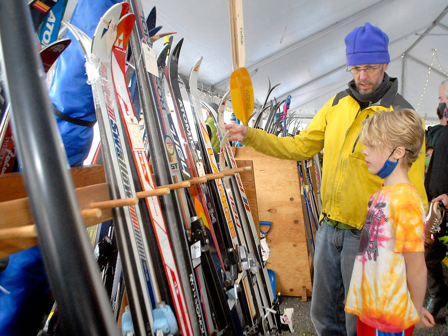 Ned Hammar of Port Angeles and his son, Felix Lubinski Hammar, 9, examine a rack of snow skies during the Winterfest ski swap in the Black Ball Ferry parking lot on the Port Angeles waterfront on Nov. 20. The event, a fundraiser for the Hurricane Ridge Winter Sports Club, featured a variety of skis, snowboards and related sports gear. Photo by Keith Thorpe/Olympic Peninsula News Group
