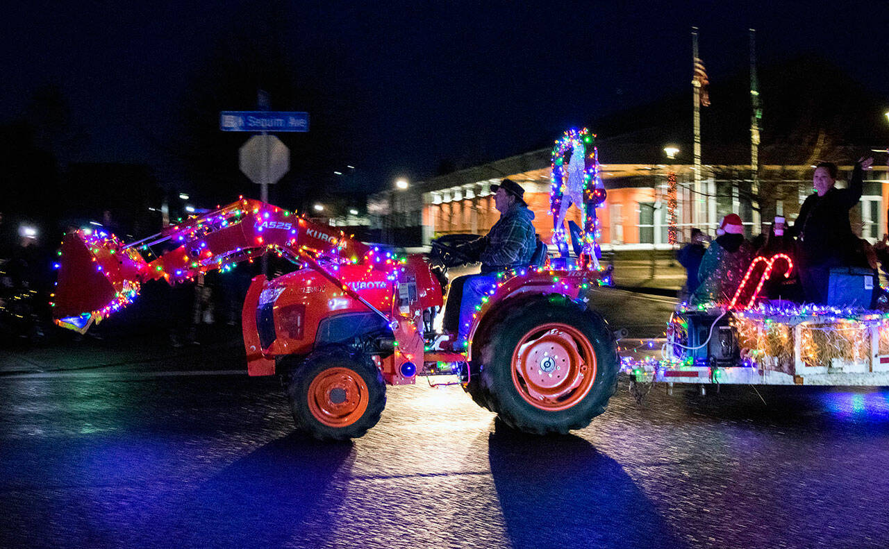 Sequim High teacher/FFA advisor Bill McFarlen drives a tractor past the Sequim Civic Center during the annual Sequim Museum Tractor Cruise on Nov. 27. Sequim Gazette photo by Emily Matthiessen