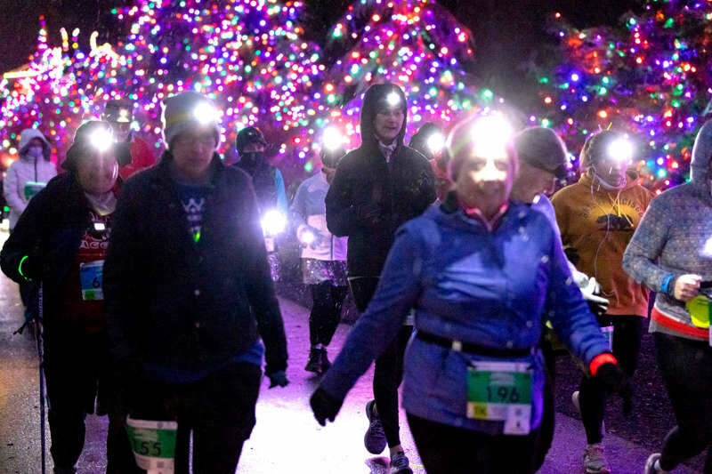Sarah Bacica, No. 196, of Sequim leads a group of runners to the finish line at the Jamestown S'Klallam Glow Run on Saturday night in Blyn. (Run the Peninsula)
