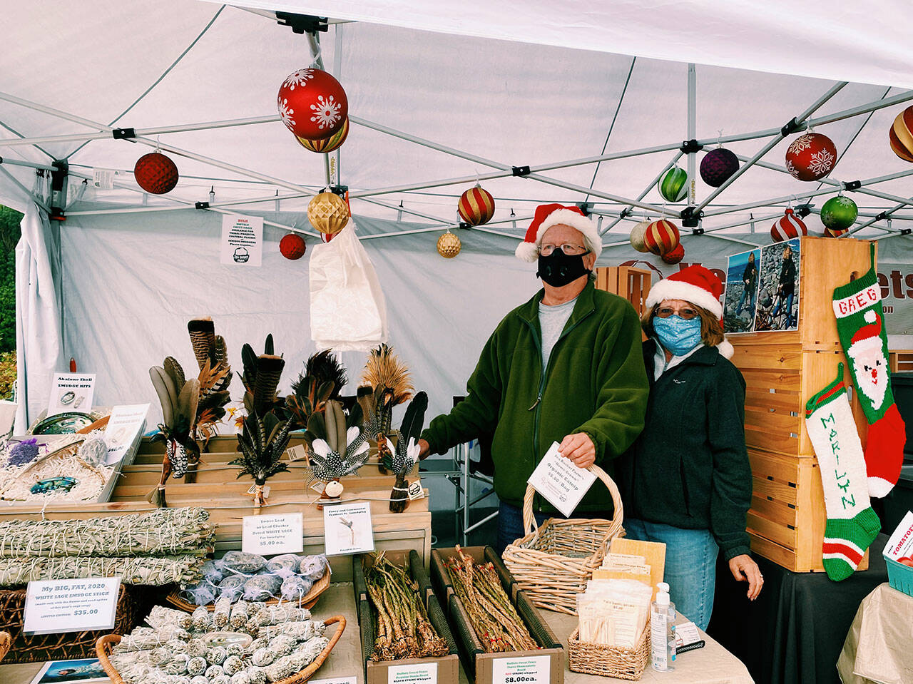 Greg and Marilyn Gundy of Sea Basket Farm spruce up for the holidays at the Sequim Farmers & Artisans Market in 2020. Photo by Emma Jane Garcia