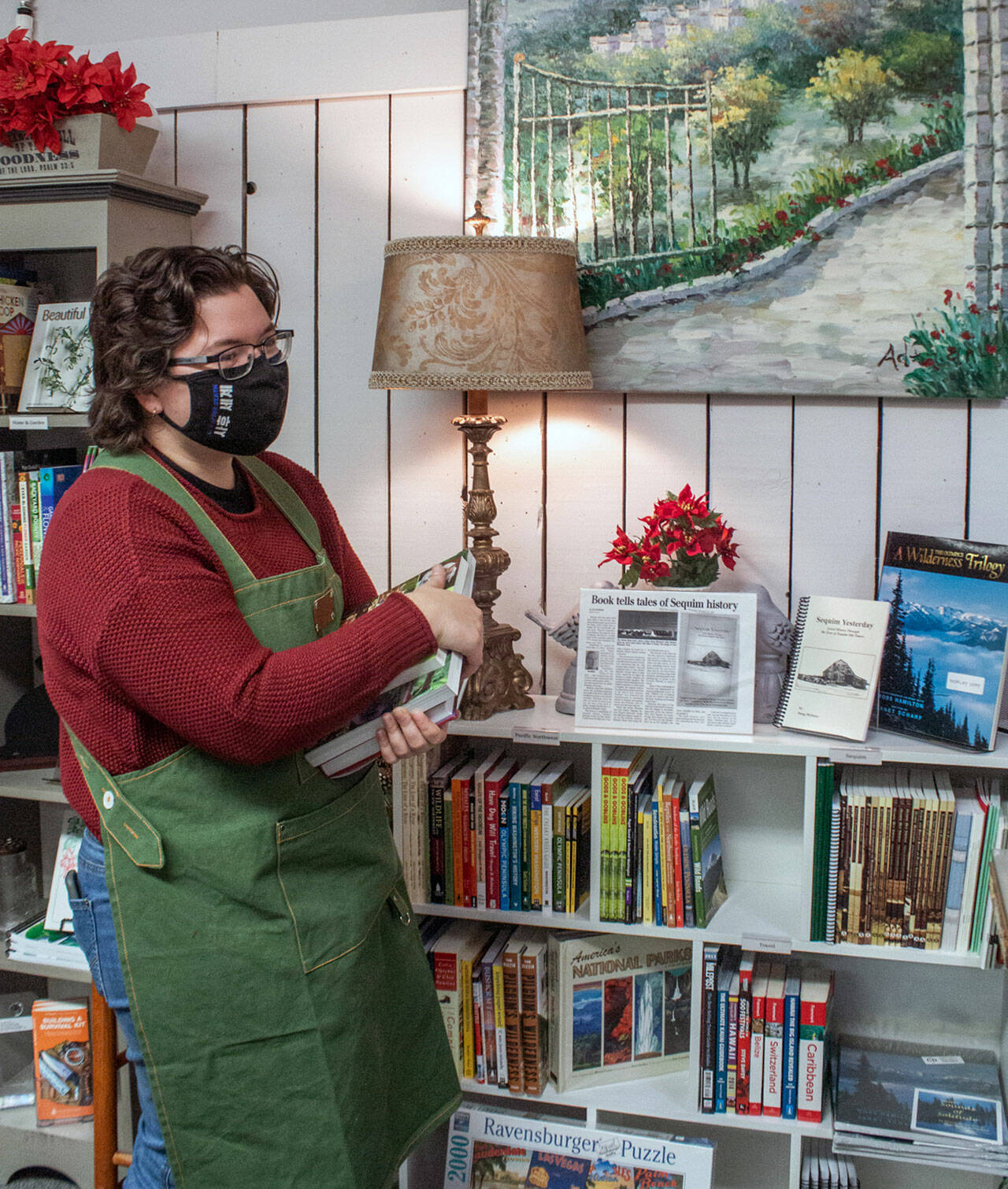 Pacific Mist sales associate Caitlin Knapple shelves books in the local section of the newly opened book and gift store. Sequim Gazette photo by Emily Matthiessen