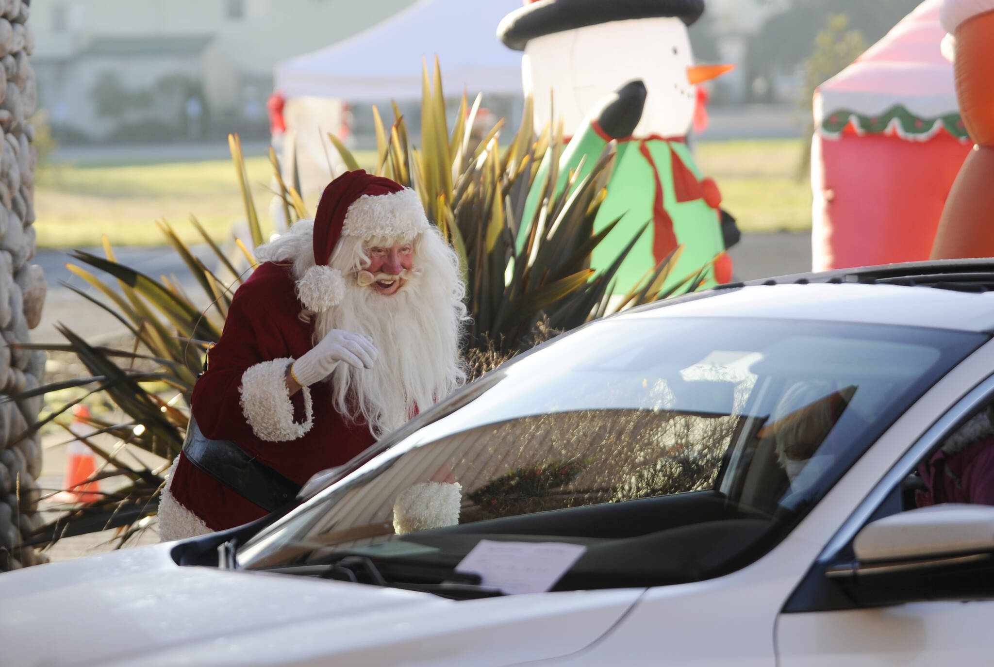 Santa Claus (Mac Macdonald) greets attendees of the “Say Hello to Santa” drive-by event on at Dungeness Valley Lutheran Church in December 2020. Hosted by First Teacher and the Parenting Matters Foundation, the event saw youths receiving a goodie bag while spending a socially-distanced visit with Mr. Claus and his group of group of volunteer elves. Sequim Gazette file photo by Michael Dashiell