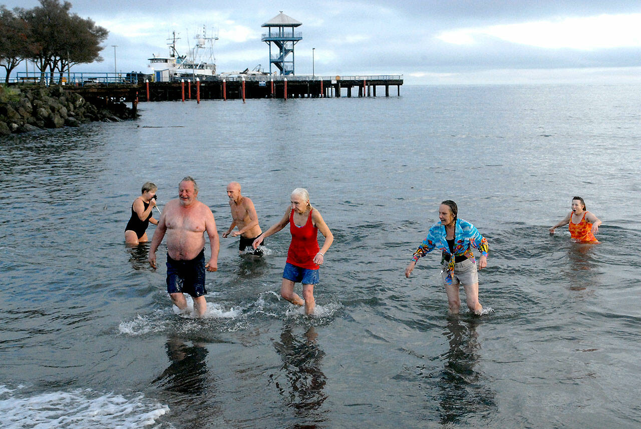 Participants in the 2021 Port Angeles Polar Bear Dip emerge from the chilly water at Hollywood Beach in port Angeles.  Although there was no organized event last year due to COVID-19 restrictions, many people showed up anyway to run to take part in the annual ritual. This year's event is set for Saturday, Jan. 1. File photo by Keith Thorpe/Olympic Peninsula News Group