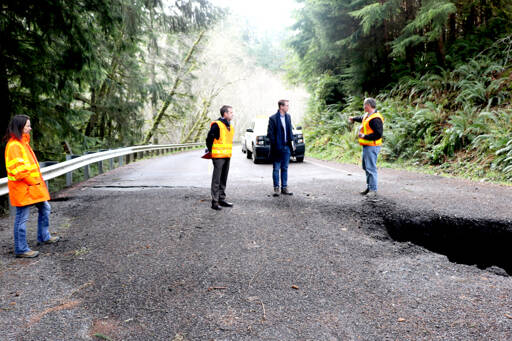 U.S. Rep. Derek Kilmer stands with workers from the state Department of Transportation who assess the damage of a landslide at Highway 112 near milepost 32. Photo by Ken Park/Olympic Peninsula News Group