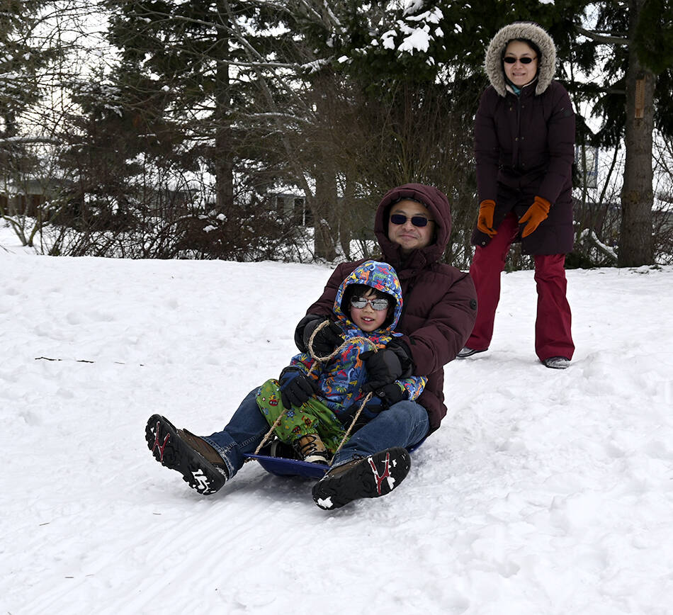 Sequim Gazette photo by Michael Dashiell
With Chunling Shen giving a push, Rui Wang and 5-and-a-half-year-old Daniel Wang of Sequim enjoy some sledding at Carrie Blake Community Park last week.