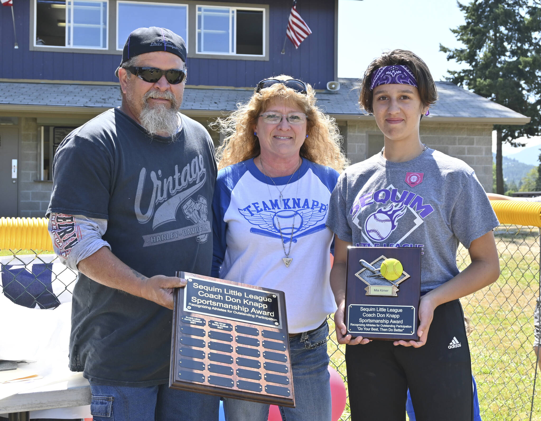 Sequim Little League softballer Mia Kirner, right, accepts the Don Knapp Sportsmanship Award from Tony and Brenda Knapp Bistline on July 10 at the league’s season-ending ceremonies. In part to honor the legacy of longtime volunteer/advocate Don Knapp, who passed away in November 2020, the league created the sportsmanship award for one baseball player and one softball player. Kirner and baseballer Bryant Laboy (who received the award at a separate ceremony) are the first recipients. Sequim Gazette photo by Michael Dashiell