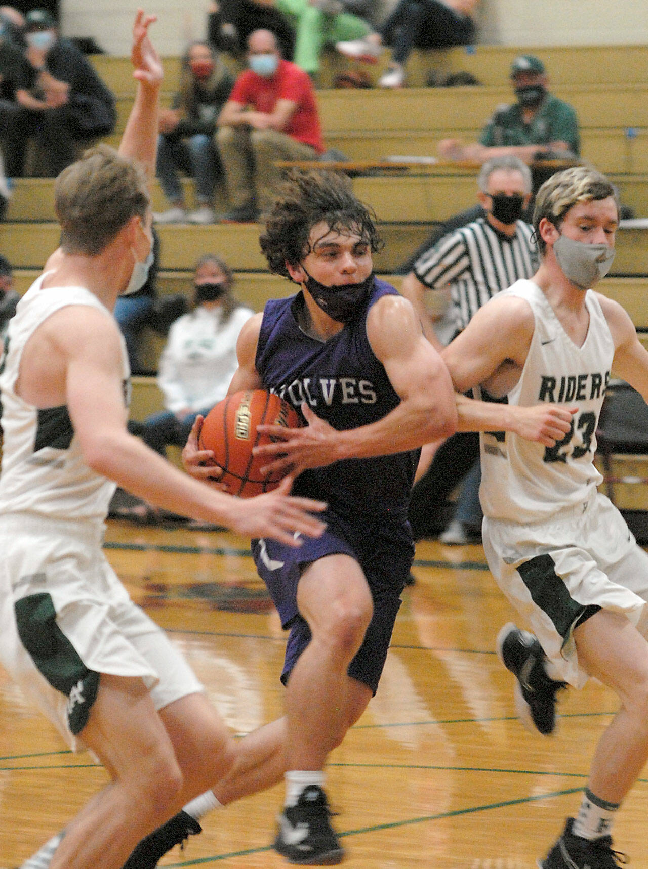Sequim’s Tyler Mooney, center, drives to the lane past Port Angeles defenders on May 12. Photo by Keith Thorpe/Olympic Peninsula News Group