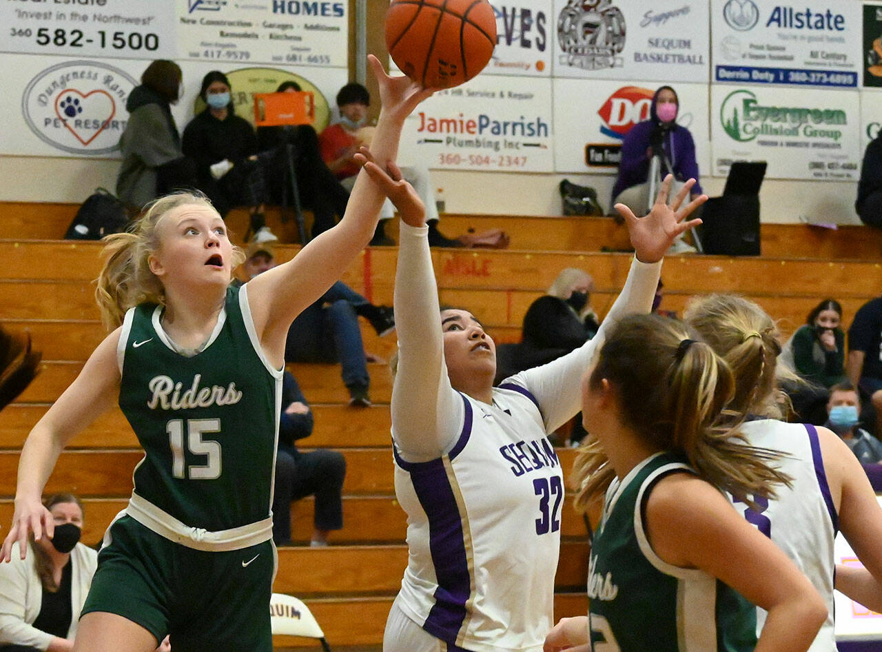Sequim Gazette photos by Michael Dashiell
Sequim’s Jelissa Julmist (32) and Port Angeles’ Paige Mason (15) vie for the ball in SHS’s 60-55 home win on Jan. 11.