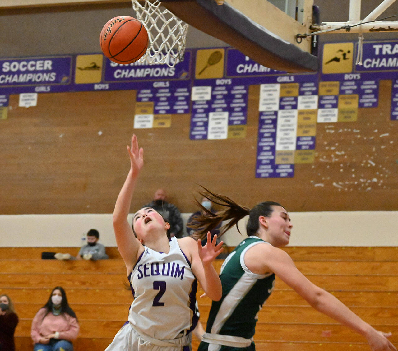 Sequim guard Hannah Bates, left, gets fouled on the way to the basket by Bailee Larson in the Wolves’ 60-55 win over Port Angeles on Jan. 11. Sequim Gazette photo by Michael Dashiell