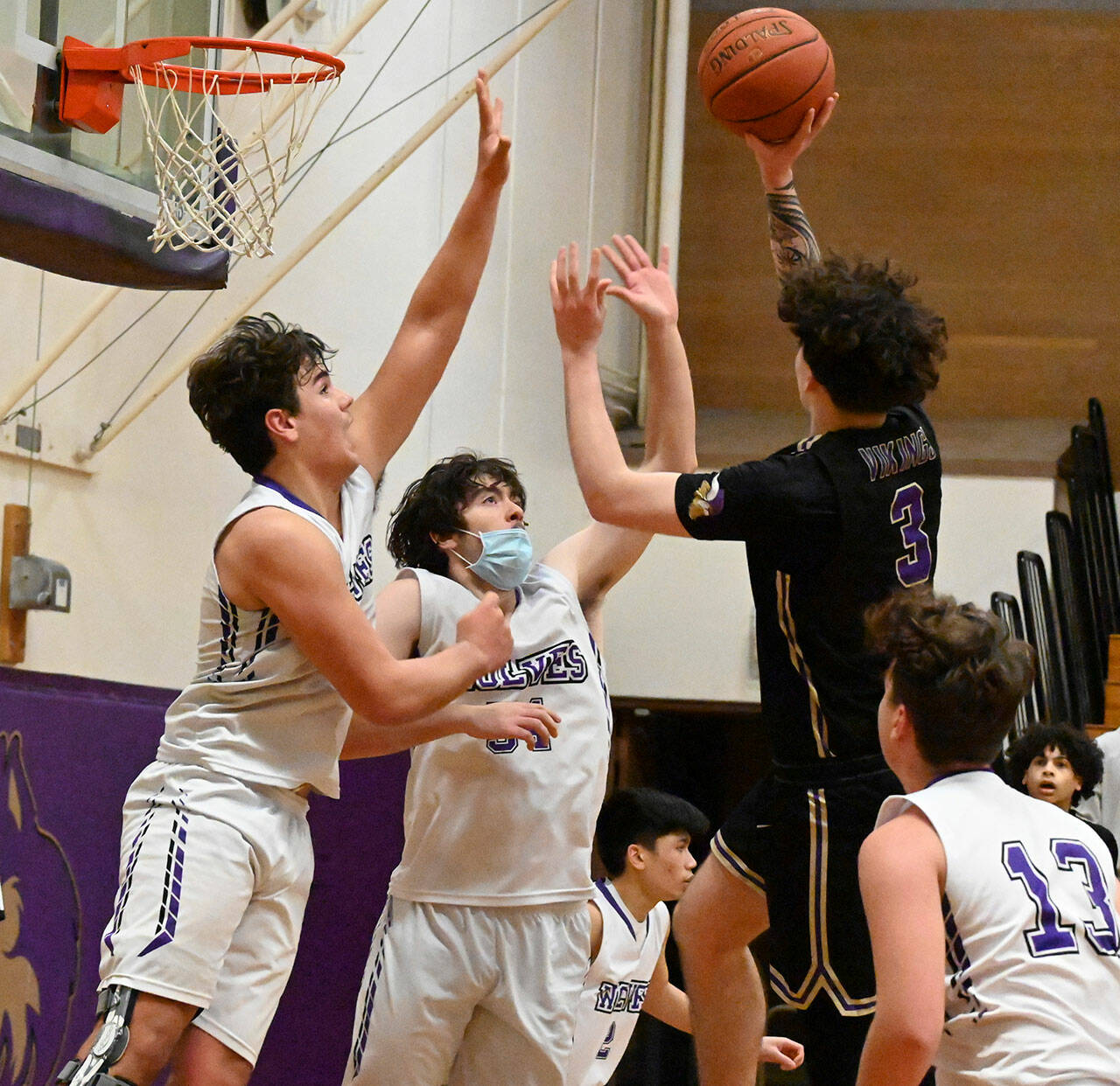 Sequim Gazette photo by Michael Dashiell
Sequims Isaiah Moore, left, and Cole Smithson, look to block a shot by North Kitsaps Aiden Olmstead in the second half of the visiting Vikings 78-40 win over Sequim on Jan. 20.
