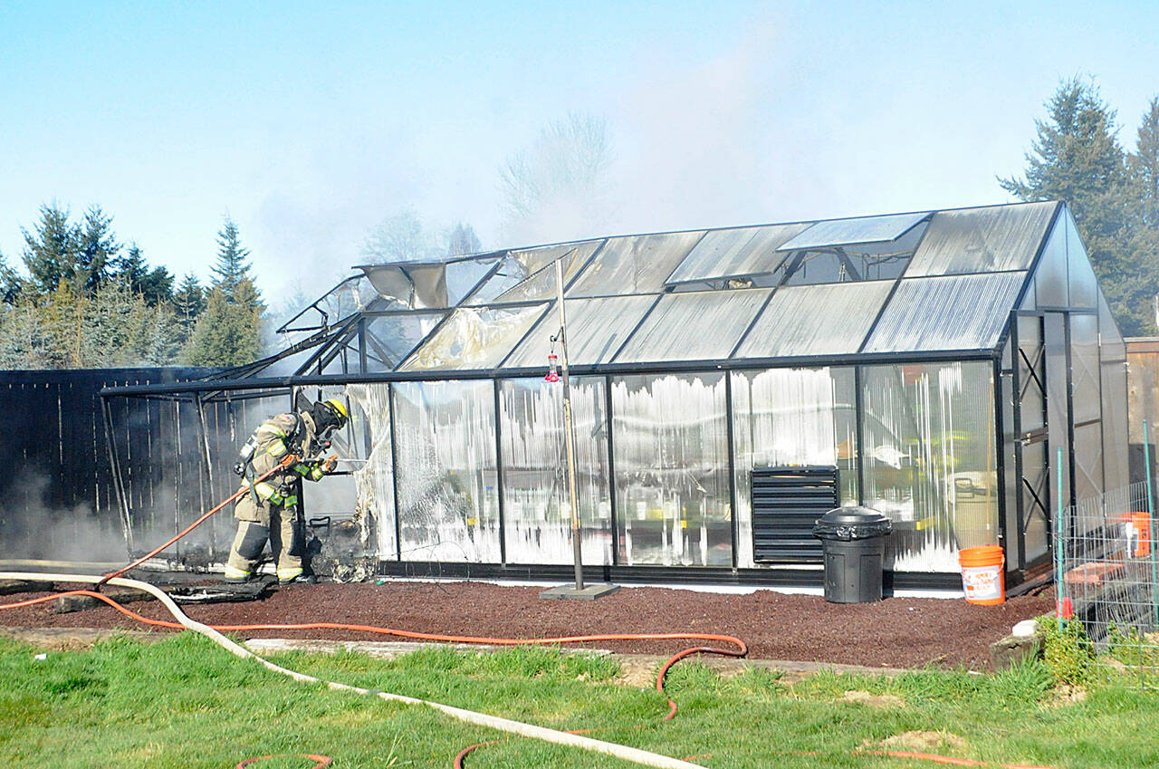 Clallam County Fire District 3 firefighters contain hot spots in a greenhouse fire on Wednesday, Feb. 16 near Heath Road. Sequim Gazette photo by Matthew Nash