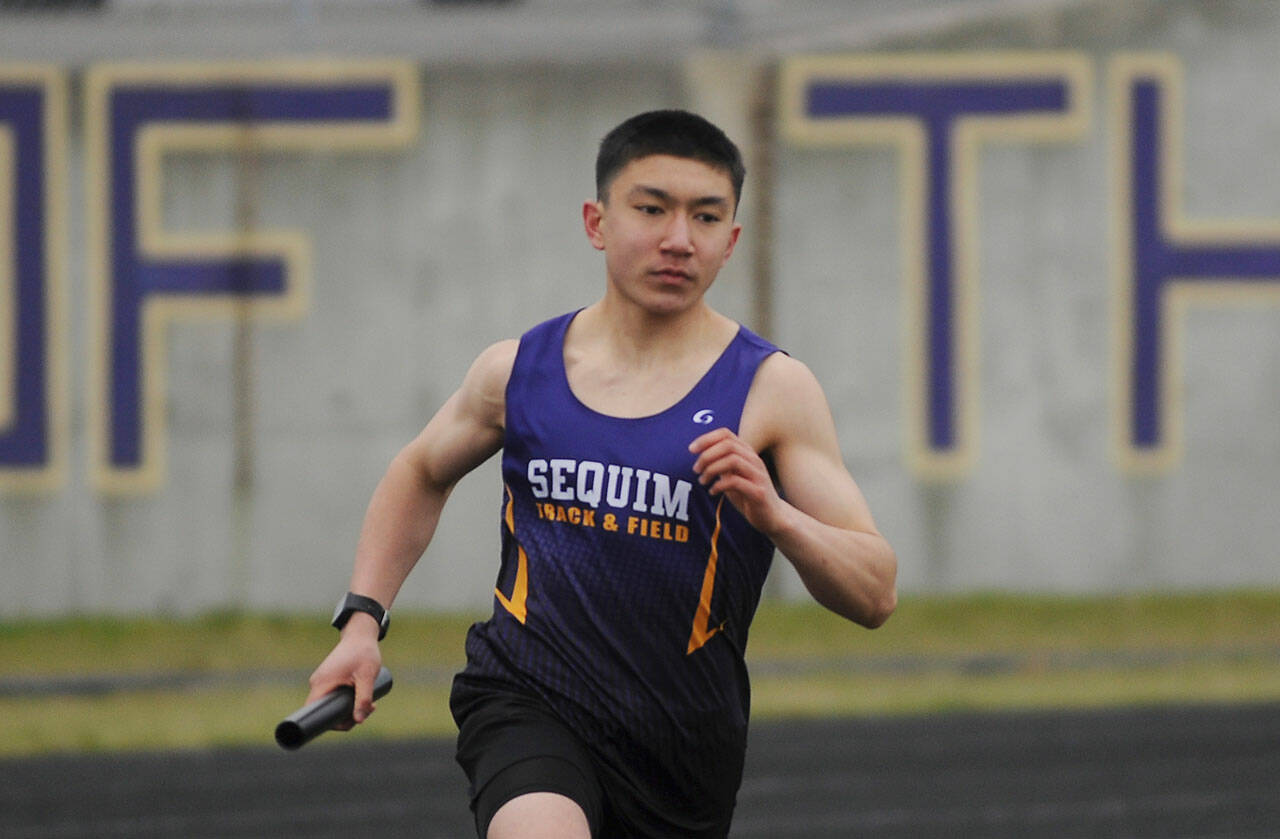 Sequim’s Koda Robinson competes in the 4x400 relay in the Wolves’ season-opening meet against Olympic in March 2021. Sequim Gazette file photo by Michael Dashiell