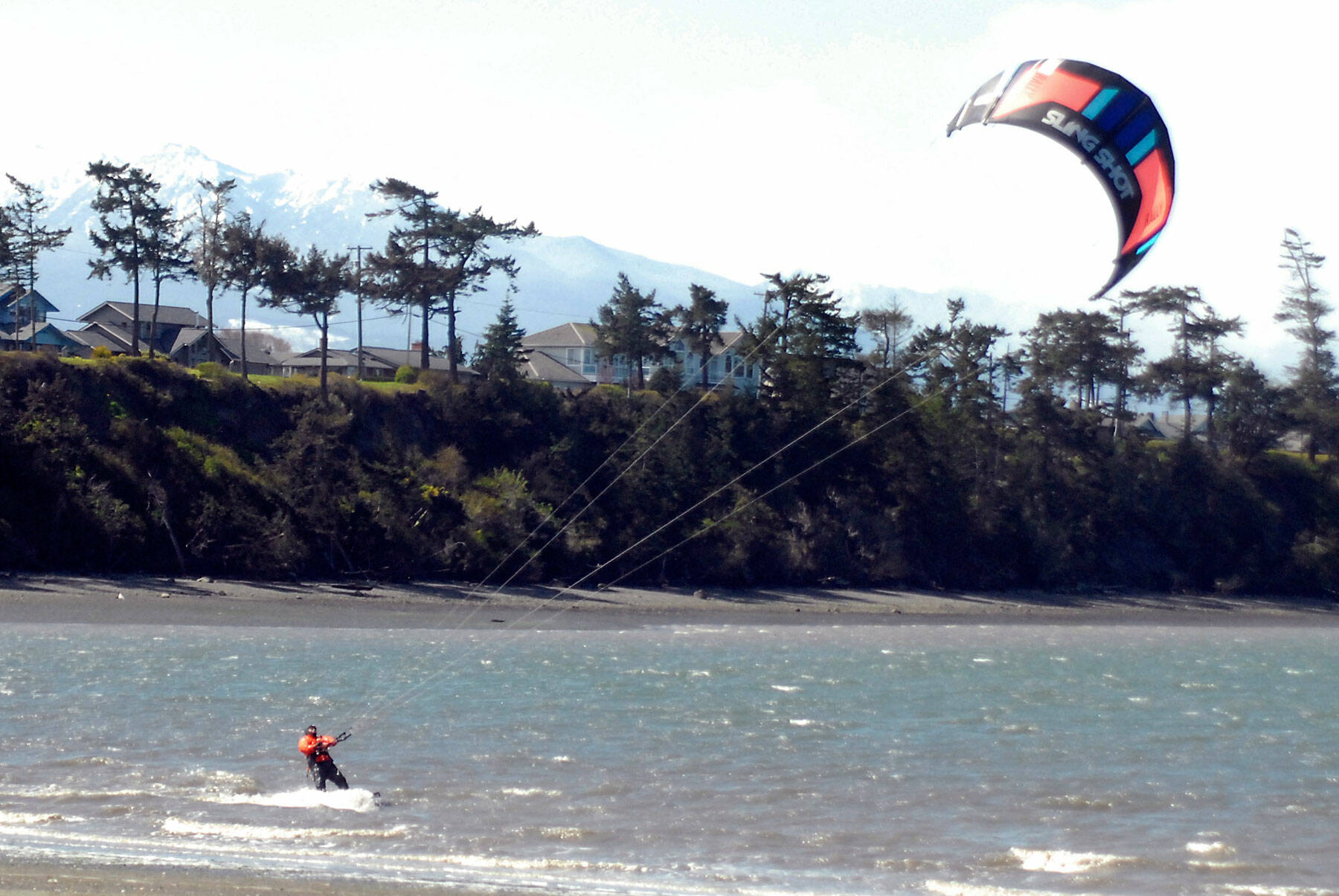 Barney Lund of Kent takes to the water off Dungeness Bay with his kite board on a blustery north of Sequim on April 5. Stiff westerly breezes prompted Lund to try his hand at harnessing the wind, he said. Photo by Keith Thorpe/Olympic Peninsula News Group