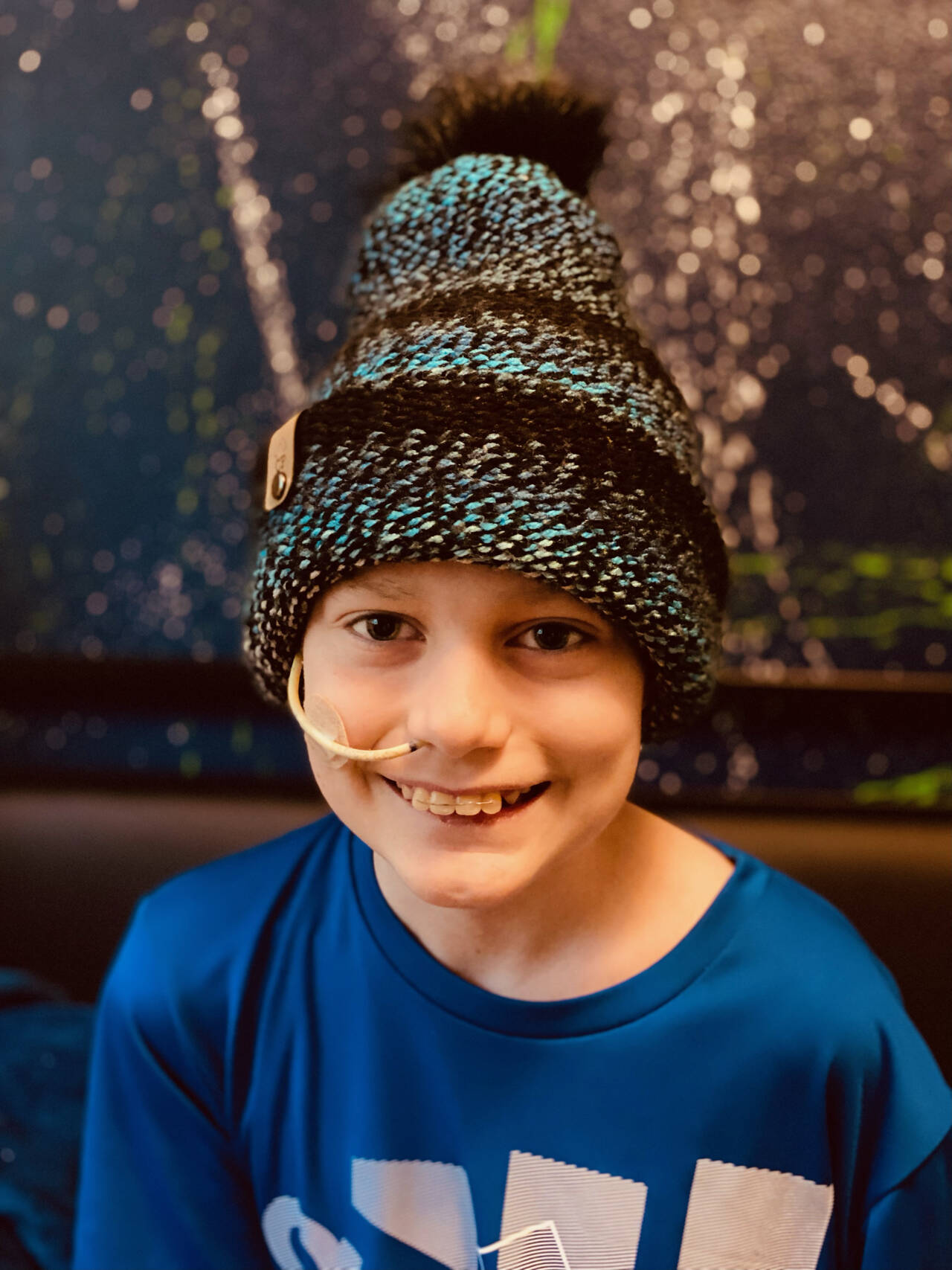 Ten-year-old Carter Pace smiles under one of Becca Pace’s knitted beanies which are available for sale at etsy.com/shop/HugYourHead and the Southern Nibble food truck. Proceeds from sales are used for supplies for Pace to knit beanies for free distribution at Seattle’s Children’s Hospital, where Carter is being treated for medulloblastoma, a brain cancer that primarily affects children ten and under. Beanies ordered on etsy are delivered free in the Sequim area. Photo courtesy of Becca Pace