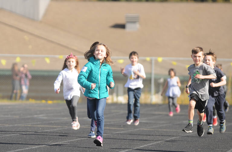 Ava Schoessler (second from left) and Weston Webb, first-graders at Helen Haller Elementary, enjoy the school's annual Fun Run, held on Earth Day (April 22). Sequim Gazette photo by Michael Dashiell