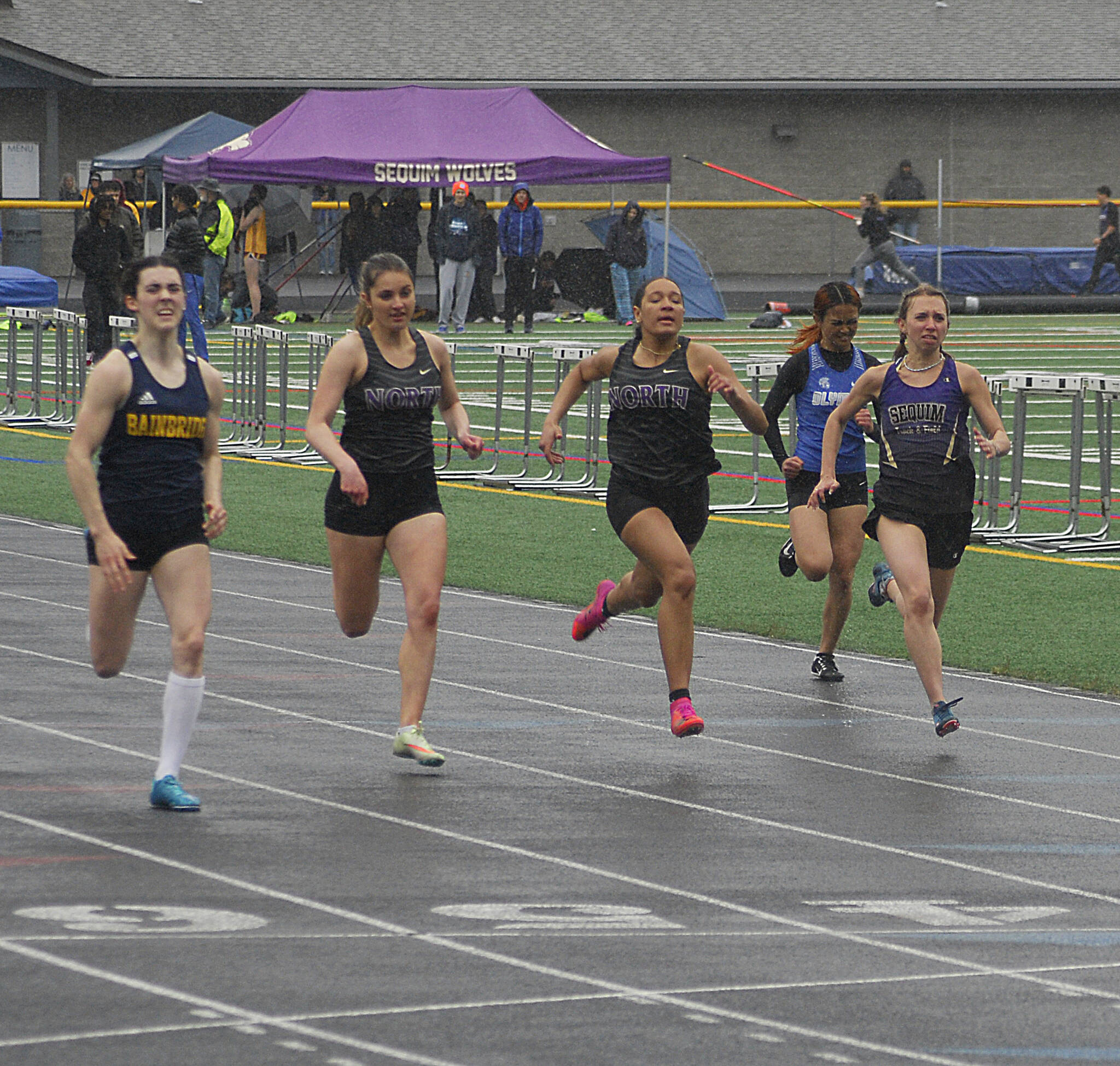 Sequim’s Hi’ilei Robinson, far right raves to a sixth-place finish in the 100 meters at the Olympic League meet in Belfair on May 5. Photo by Joanne Huemoeller