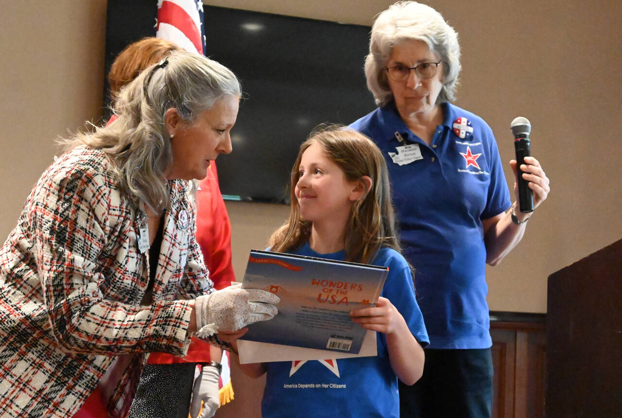 Judy Tordini, left, and Marianne Burton of the Michael Trebert Chapter of the Daughters of the American Revolution present Oakley Black with an award for participation in the group’s Junior American Citizens group at a recognition luncheon on May 10 at The Cedars at Dungeness. The group received a first place honor in the JAC Community Service Contest of The National Society of the Daughters of the American Revolution earlier this year. “When learning is fun, it really sticks,” Burton said. Sequim Gazette photo by Michael Dashiell