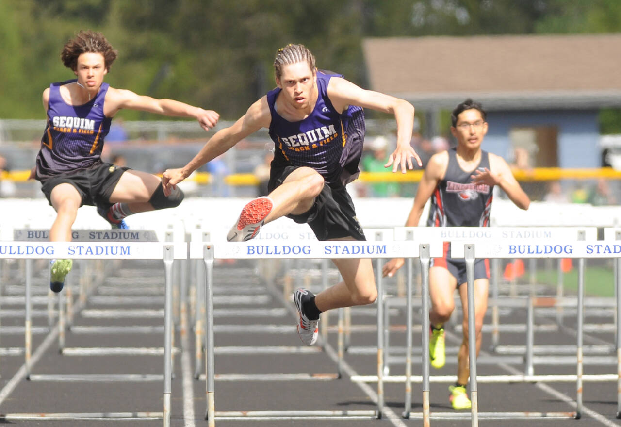 Sequim’s Adrian Brown, center, won the district championship in the 110-meter hurdles. At left is brother Andrew Brown, who came in fifth and second in the high jump. (Michael Dashiell/Olympic Peninsula News Group)_