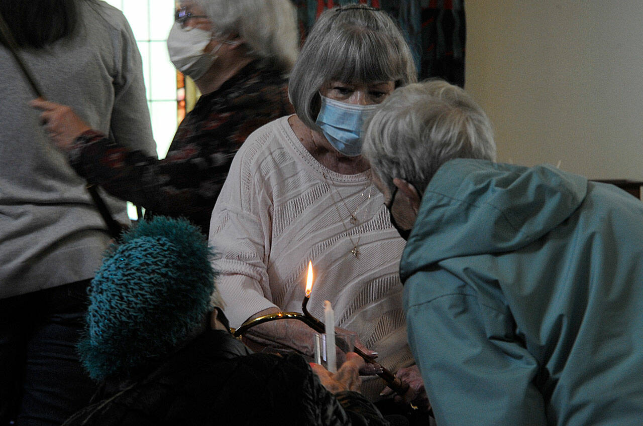 Sequim Gazette photo by Matthew Nash/ Pat Rublaitus helps light candles for a candlelight prayer service on May 27 inside St. Luke’s Episcopal Church in Sequim for the victims of the Robb Elementary School shooting in Uvalde, Texas. About 40 people attended to pray and sing for the teachers and students and their families.