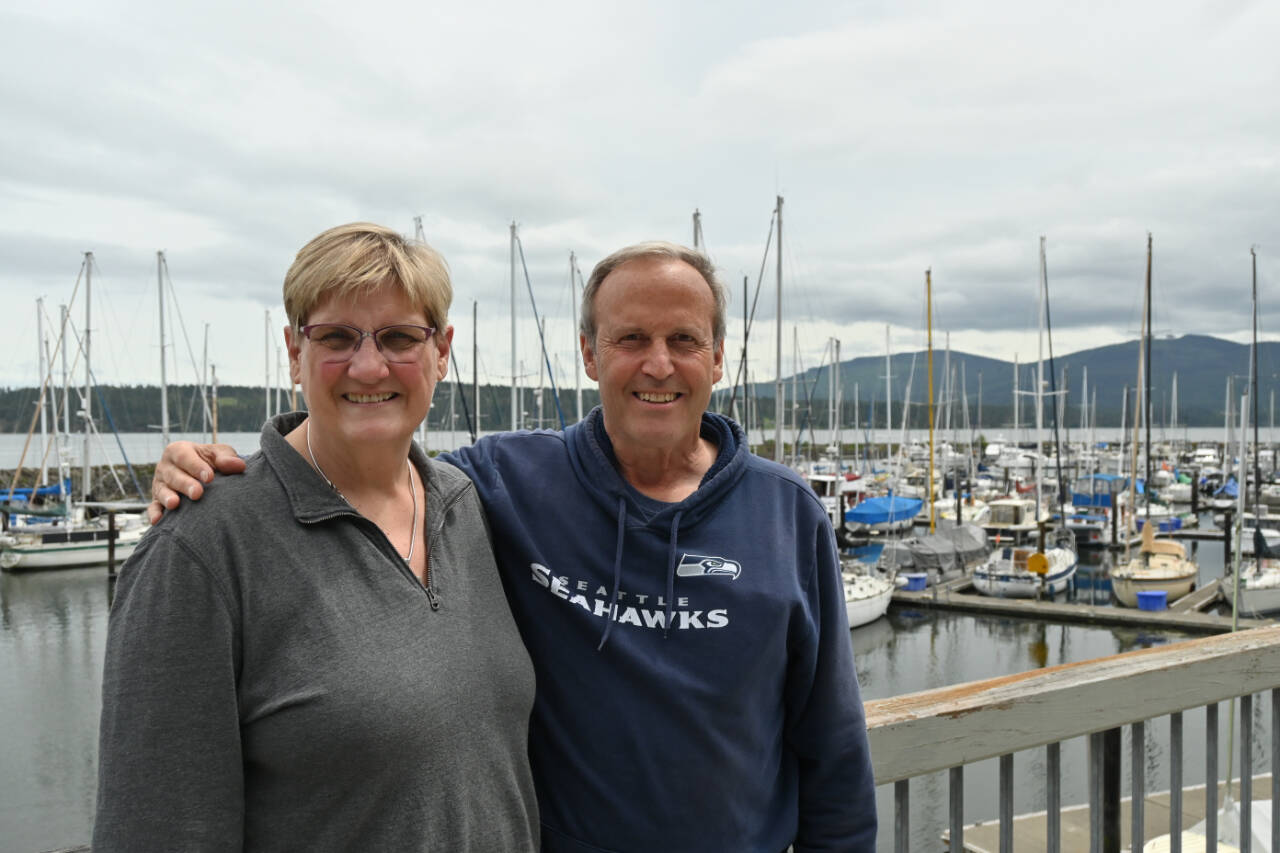 Susan Sorensen, an organizer and publicity chair for the Reach and Row for Hospice, and Mike Crim, one of the founders of the race, enjoy tales of the event’s origins at Sequim Bay Yacht Club in early June. Sequim Gazette photo by Michael Dashiell