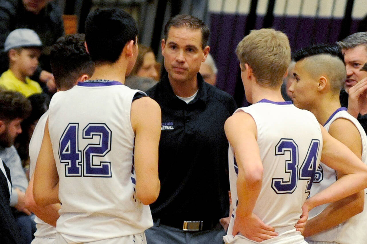 Sequim High head coach Greg Glasser, center, talks to Isaiah Moore, left, and Erik Christiansen during a timeout in the Wolves' 51-46 win over North Mason in January 2020. Sequim Gazette file photo by Conor Dowley