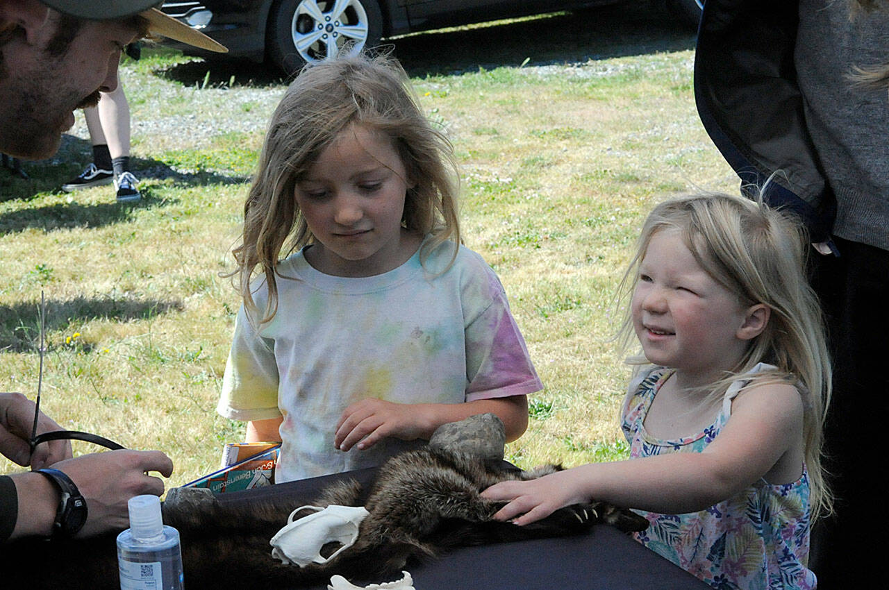 Sequim Gazette photo by Matthew Nash
Edith, 5, and Louisa Gilles, 3, speak with Olympic National Park ranger Coady Johnson on June 23 during the kickoff of the Sequim Library’s Summer Reading Program. Events take place all summer along with chances for readers to win prizes and earn T-shirts.