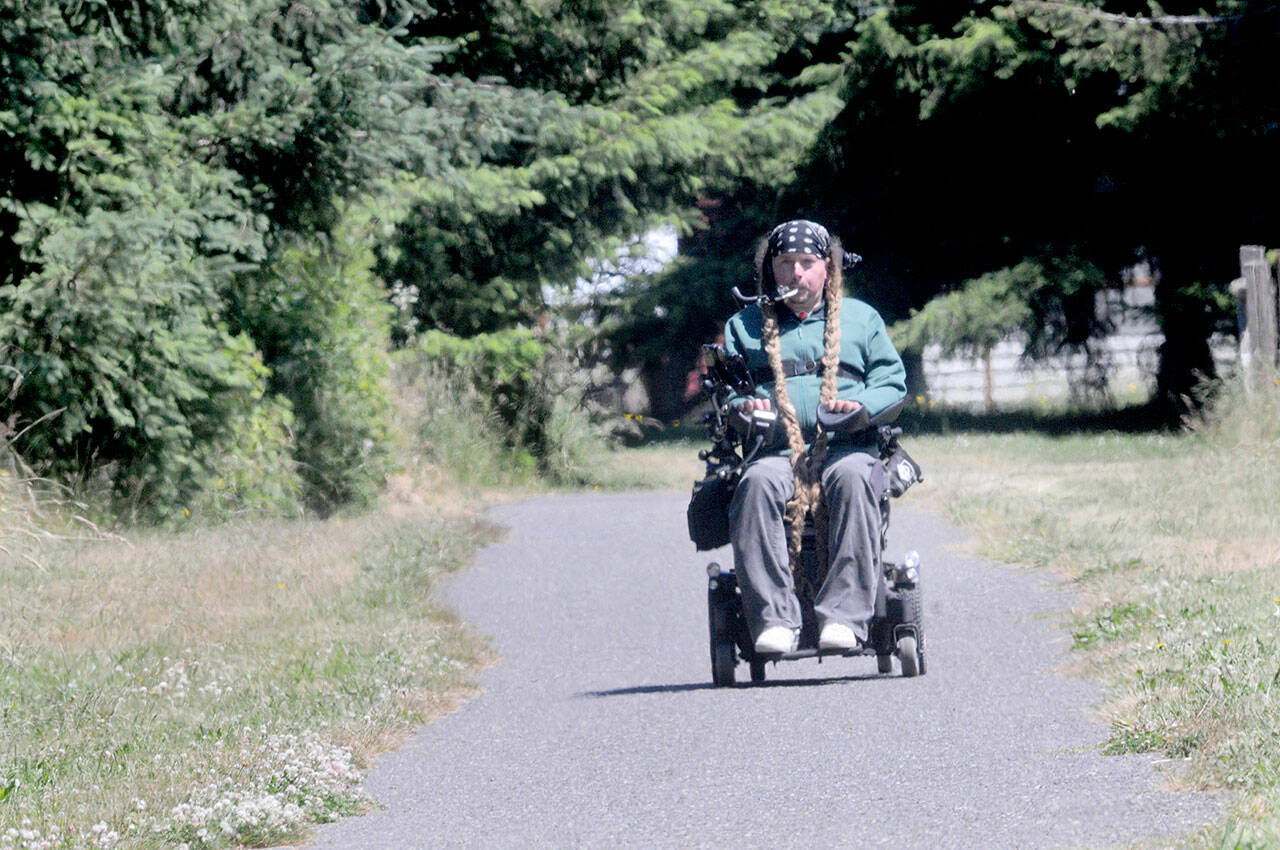 Photo by Keith Thorpe/Olympic Peninsula News Group
Ian Mackay rides his motorized wheelchair on a section of the Olympic Discovery Trail at Robin Hill County Park west of Sequim on July 1.