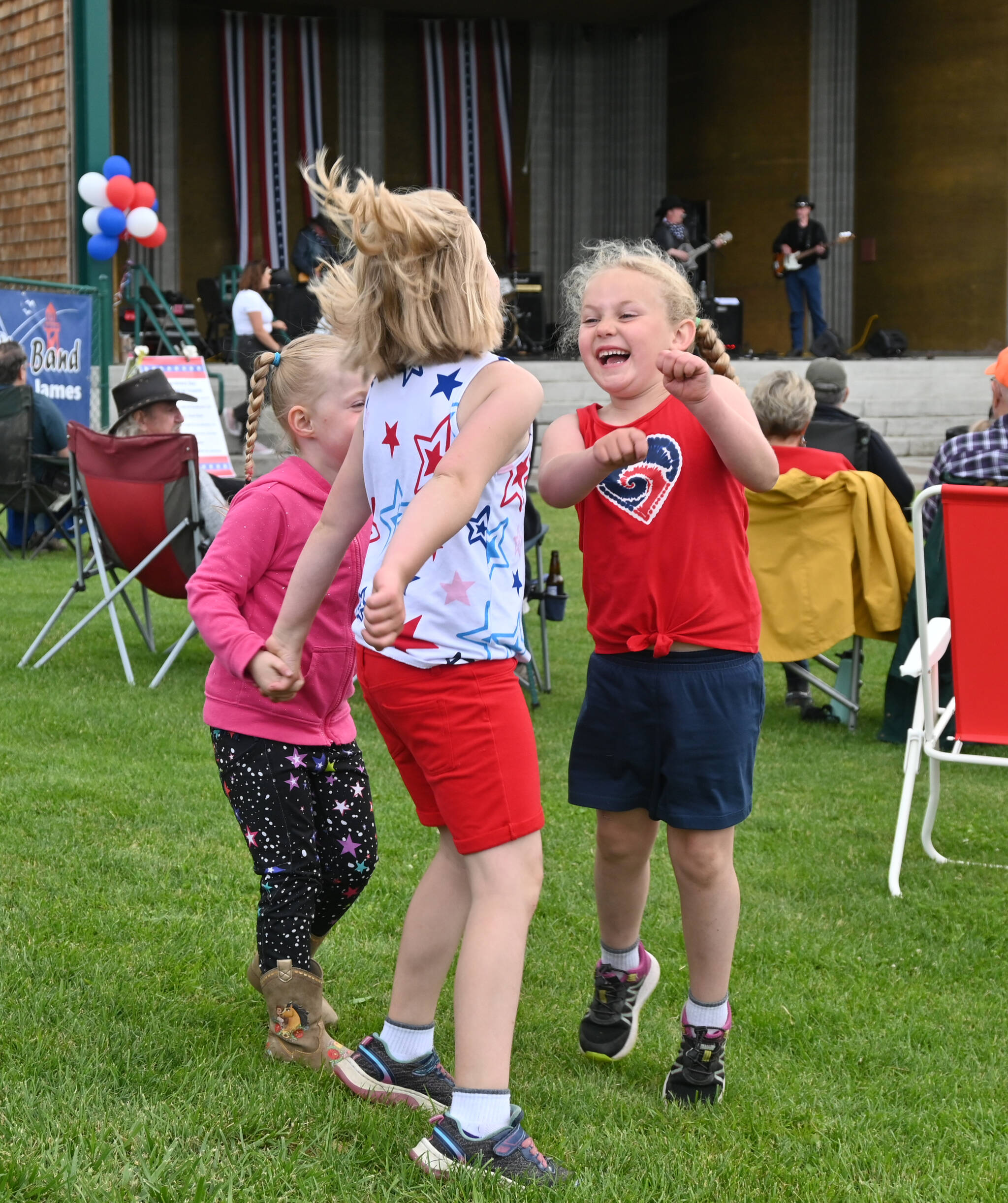 Sequim Gazette photo by Michael Dashiell / From left, Willa Steele, 4, Amelia McBride, 7, and Alexis McBride, 6, enjoy the tunes of the Buck Ellard Band at the Independence Day Celebration at the James Center for Performing Arts on July 4.