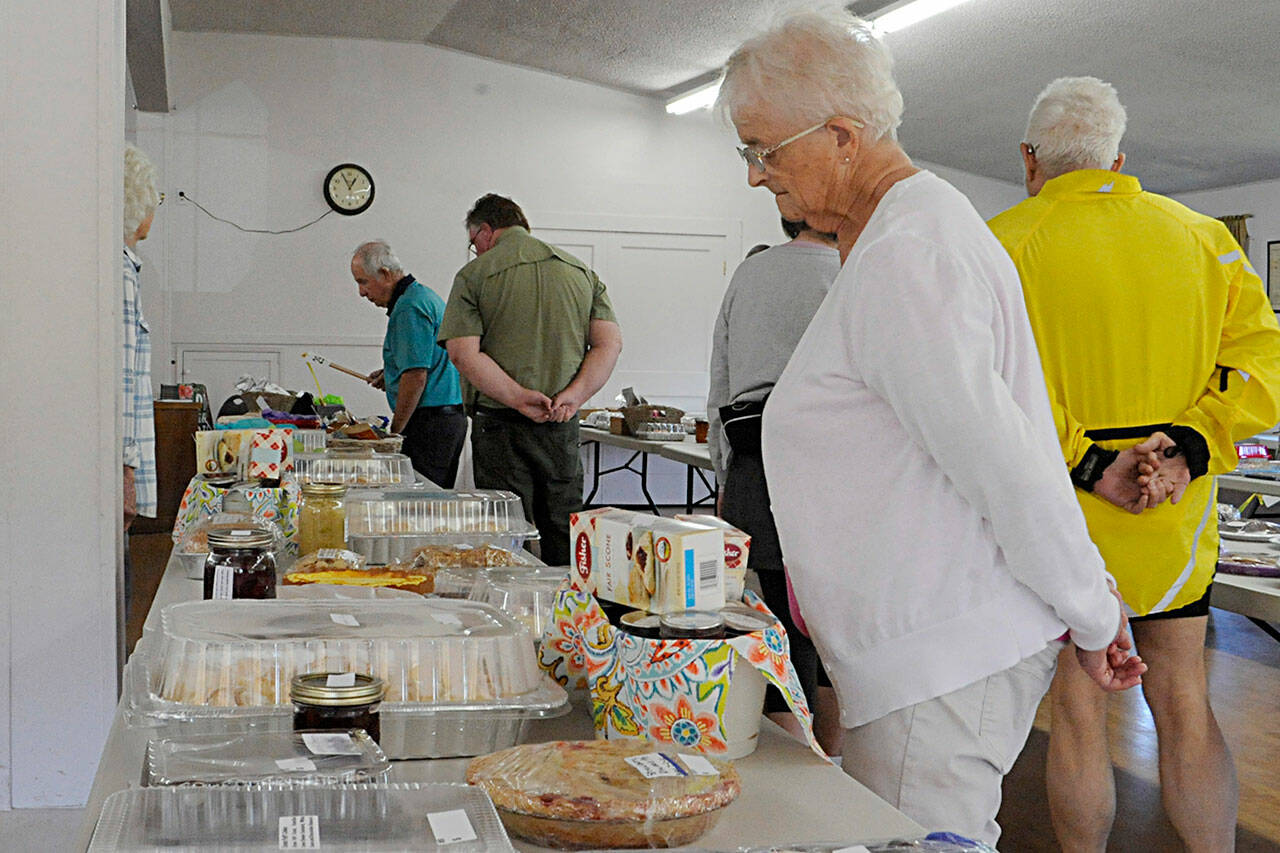 Sequim Gazette photo by Matthew Nash/ Davona Guin with the Humptulips Grange looks at some of the 192 dessert items on July 23 in Sequim. She made some brownies for the auction, too.