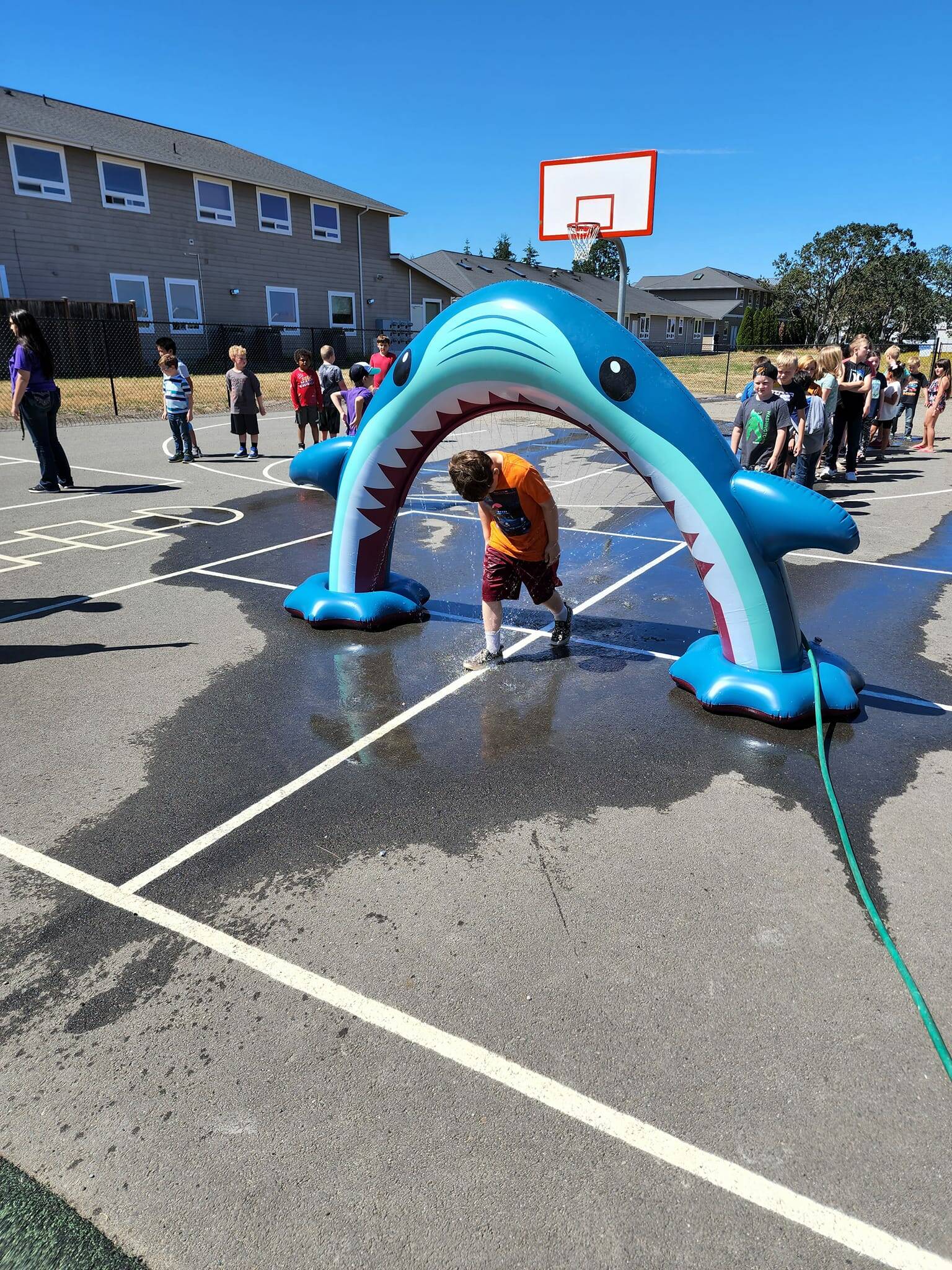 Submitted photo
Club members with the Boys & Girls Club of Sequim stay cool and celebrate Shark Week with an inflatable shark on their playground.