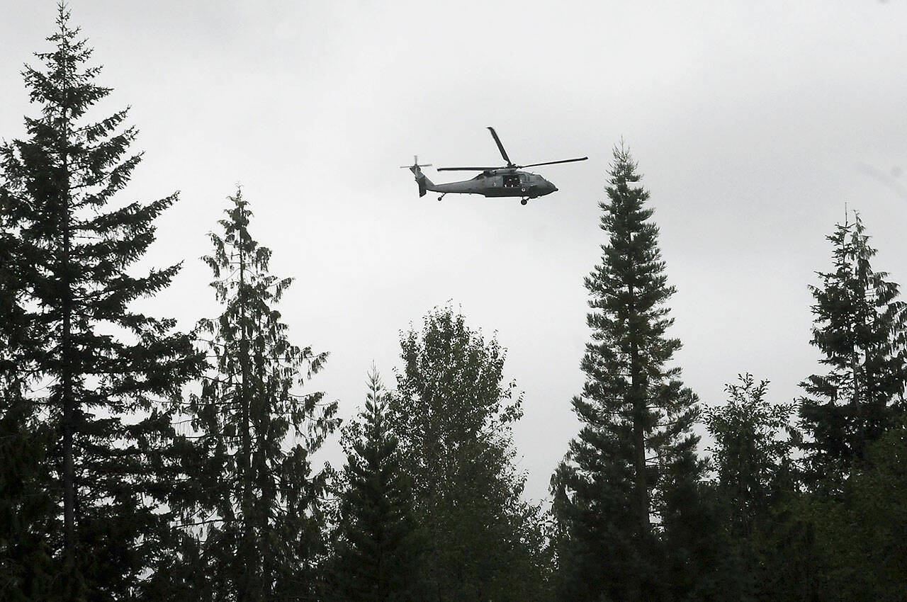 Keith Thorpe/Olympic Peninsula News Group / A rescue helicopter from Naval Air Station Whidbey Island circles the area where a plane crashed on Aug. 10 in forested terrain southwest of Gardiner.