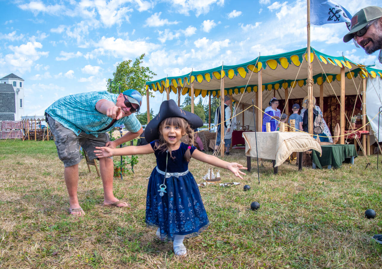 Sequim Gazette photo by Emily Matthiessen / Aliya Jones, 3, “having a blast,” as her father Clint Jones says, heads towards the camera in her tricornere hat, outside the Barcelona Trading Company tent at the PNW Colonial Festival on Friday.