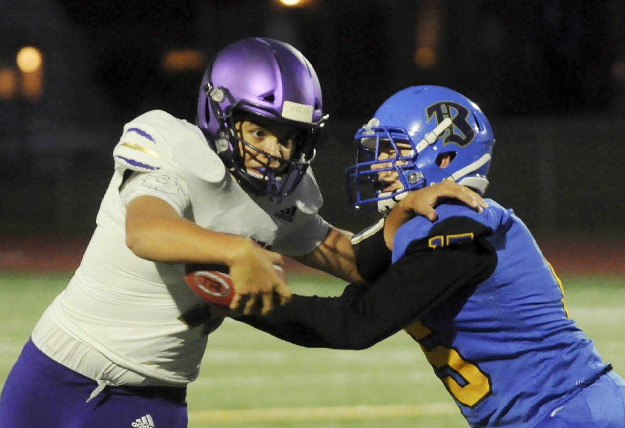 Sequim Gazette file photo by Michael Dashiell
Sequim quarterback Lars Wiker looks to break free of a tackle in an Olympic League game at Bremerton in 2021.
