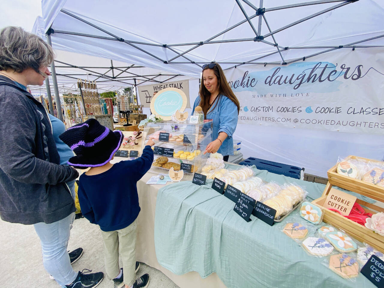 Photo by Emma Jane Garcia/Sequim Farmers & Artisans Market / Sarah Harrington greets customers at the Cookie Daughters booth at the Sequim Farmers & Artisans Market.