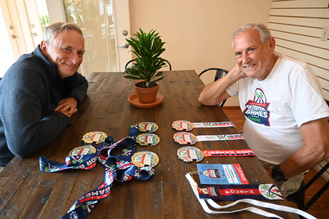 Sequim Gazette photo by Michael Dashiell / Phil Milliman, left, and his father Chuck display some of the many medals they earned at the 2022 National Senior Games.